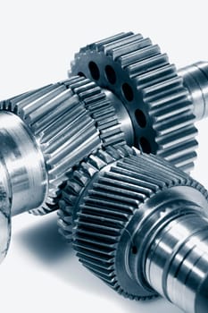large titanium gears and cogs, used in aerospace industry, set against light background. ideal for isolations