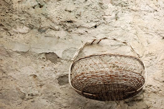 An old wicker basket by the stone wall