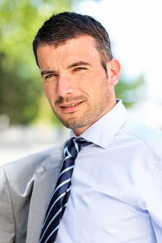 beautiful young businessman with tie outdoor in spring