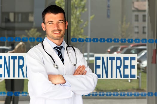 young doctor in front of hospital entry