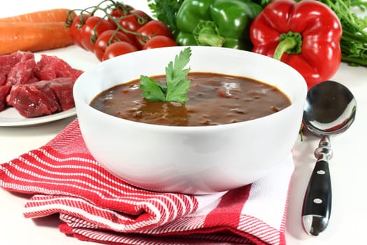 a bowl of goulash soup and fresh ingredients