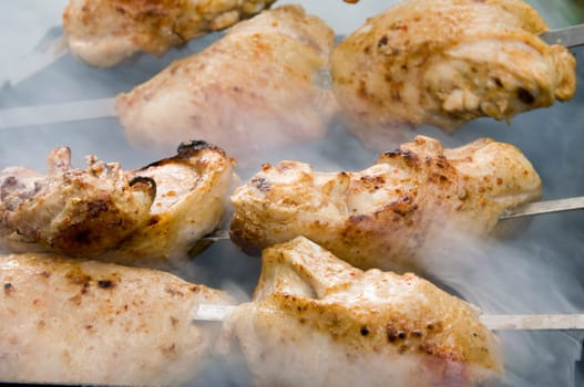 there is cooking outdoor a chicken  grilled