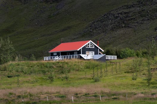 black house with red roof and white trim in Iceland