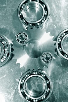 ball-bearings and steel gears, set against brushed aluminum, engineering parts