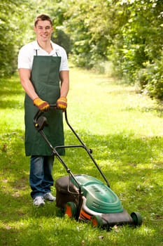 Young gardener with a lawn mower