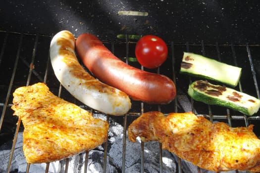 Meat slices,sausages and vegetables on the charcoal grill