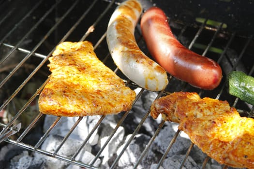 Meat slices,sausages and vegetables on the charcoal grill