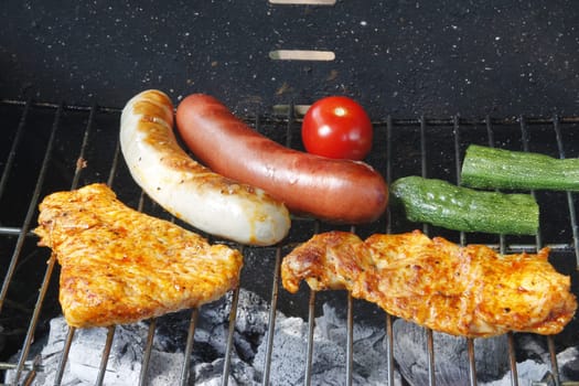 Meat slices,sausages and vegetables on the charcoal grill