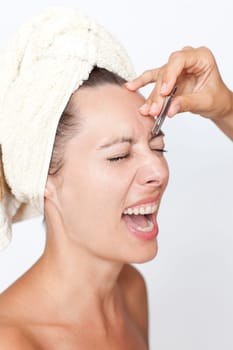 Woman plucking eyebrows