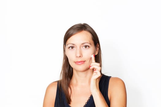Attractive woman applying cream on her face