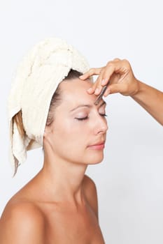 Woman plucking eyebrows