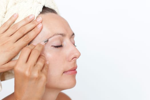 Woman plucking eyebrows