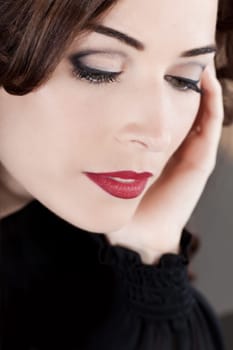 Closeup portrait of a beautiful middle aged woman with red lips looking down