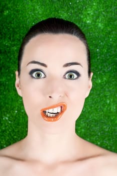 Closeup portrait of a woman funny grimacing  isolated on green