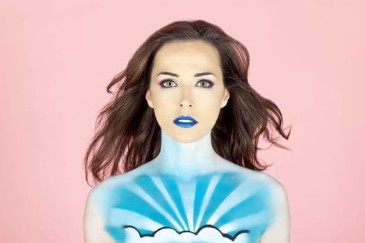 Closeup portrait of a beautiful woman with sky painted on her body isolated on pink background