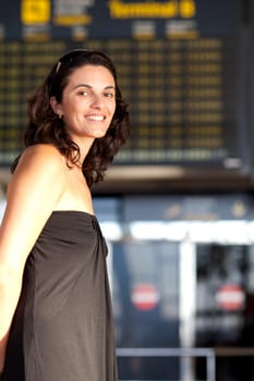 Woman waiting in front of a display board at the airport
