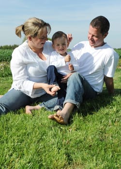 Cheerful parents and toddler on a meadow