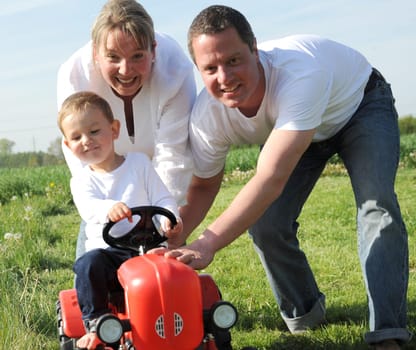 Parent and child with red toy tractor