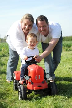 Parent and child with red toy tractor