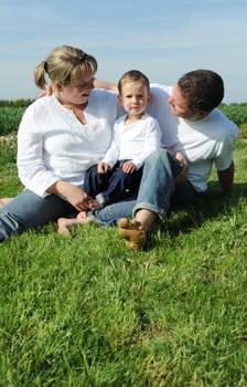 Cheerful parents and toddler on a meadow