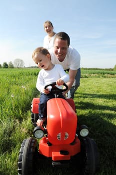 Parents and toddler with red tractor