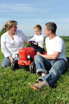 Parent and child with red toy tractor