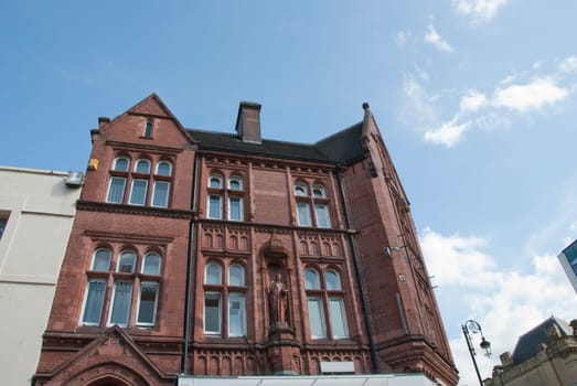 A Nineteenth Century Former Insurance Company Office built of red brick with statue