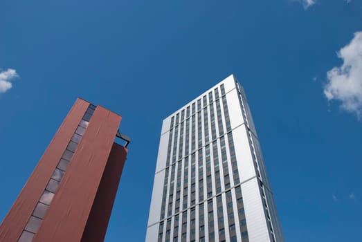 Two Red Brick and White Tower Blocks under a blue summer sky