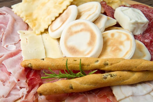 a platter of mixed cured meats, cheeses and fried dumpling