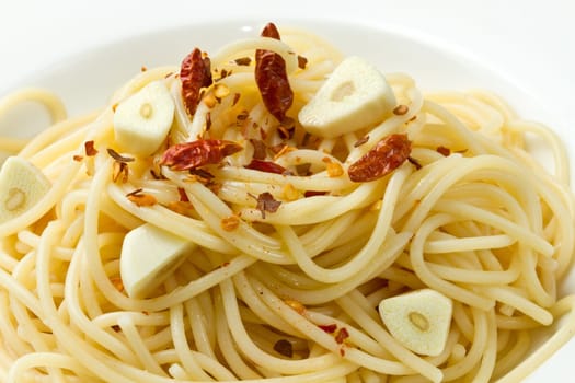 pasta garlic olive oil and red chili pepper closeup on a white dish