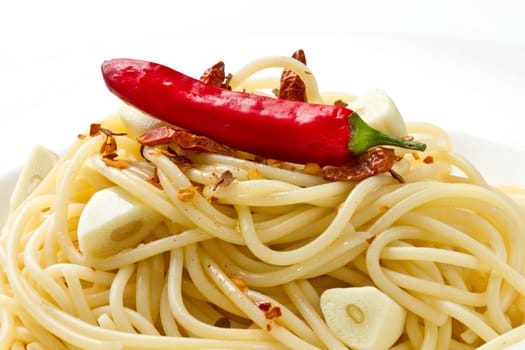 pasta garlic olive oil and red chili pepper closeup on a white dish