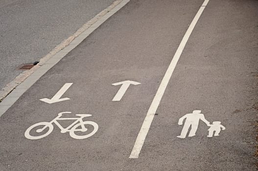 Painted signs on asphalt for pedestrian and bicycle dedicated lanes