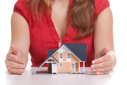 Woman protecting model of house. Realty investment protection concept. Selective focus on house.