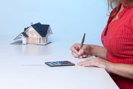 Real estate broker calculating amount of payments family house mortgage. Focused on calculator.