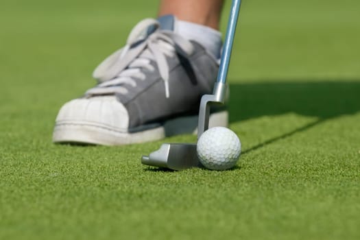 Golfer, golf ball and driving-putter close-up