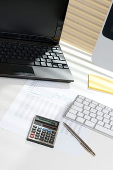 Modern business analyst workplace with laptop and computer