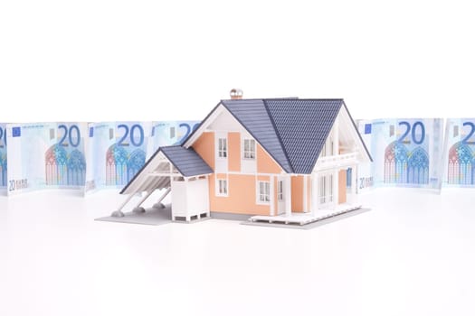 Housing finance, building savings and realty financing (investments) concept. Money wall and model of the family house.