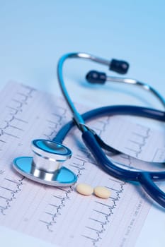 Part of stethoscope, electrocardiogram (ECG) and two pills