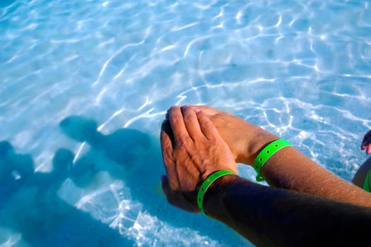 A couple on a beach, wearing a braclet from an all inclusive hotel