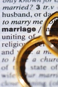 Two wedding rings next to the word "marriage"" on a english dictionary"