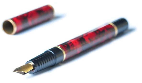 A fountain writing pen, brown and black with a gold tip, isolated in white