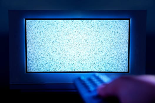Someone holds a tv remote control late at night and tries to find a tv show to fight insomnia