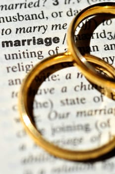 Two wedding rings next to the word "marriage"" on a english dictionary"