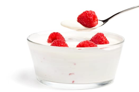Raspberry on a spoon with yogurt over a dessert on a white background