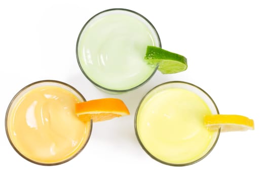 Three cold citrus milkshakes from above on white background