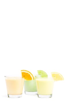 Three cold citrus milkshakes on white background