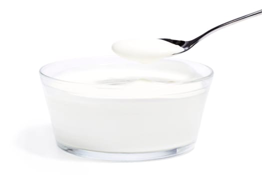 Yogurt in a bowl with a spoonful of yogurt on a white background