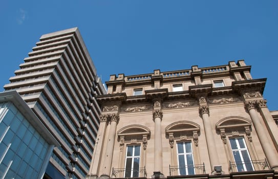 A Skyscraper and a vintage stone building in an english city