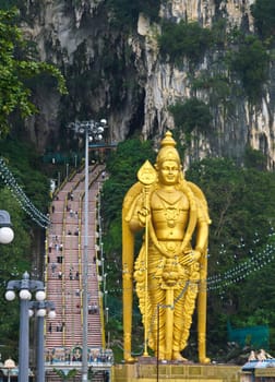 The large gold hindu statue in front of Batu caves in Malaysia.