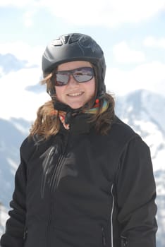 Young woman in winter sports clothes - mountains in the background
